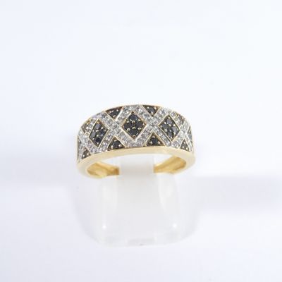 gros plan d'une bague en or avec des diamants noirs et blancs
