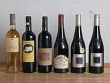 plusieurs bouteilles de vin sont alignées sur une table en bois