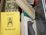 une boîte remplie de livres et une horloge posée sur une table