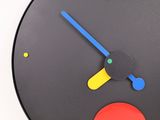 a black clock with a red circle on the face
