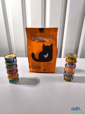 three cans of cat food and a bag of cat food on a table