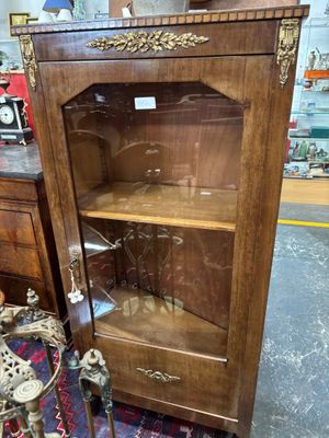 un meuble en bois avec une porte en verre dans une pièce