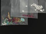 deux sachets de perles et une paire de ciseaux posés sur une table