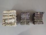 three stacks of newspapers wrapped in twine and tied with twine
