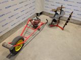 a red cart with a yellow wheel next to a wall