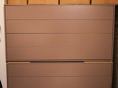 a brown chest of drawers in the corner of a room