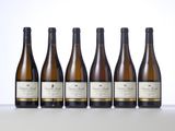 six bottles of white wine lined up on a table