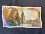 a close up of a fifty pound bank note with a clock tower in the background