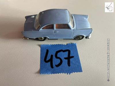 une petite voiture posée à côté d'une feuille de papier