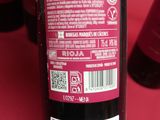 a bottle of red wine sitting on a table next to a bottle of wine