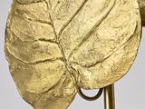 a gold sculpture of a leaf on a stand