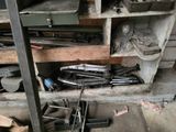 a pile of tools sitting on a shelf in a garage