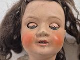 a close up of a doll with long hair on a white background