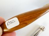 une personne tenant une cuillère en bois sur laquelle est collé un autocollant