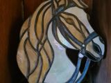 une tête de cheval en verre posée sur une étagère en bois dans une pièce