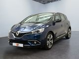 Une voiture bleue est garée dans une pièce au sol noir.