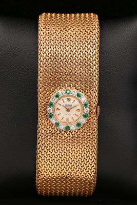 une montre-bracelet en or 18 carats sertie d'émeraudes et de diamants