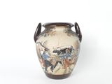 a vase with a painting on it sitting on a table