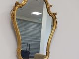 un miroir doré accroché au mur d'une pièce