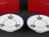 two cups and saucers with a red box on a table