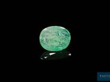 un gros plan d'une émeraude verte sur une surface noire