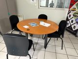 une table et des chaises dans une pièce où sont accrochés des tableaux au mur