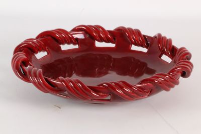 une image représentant un bol rouge posé sur une surface blanche