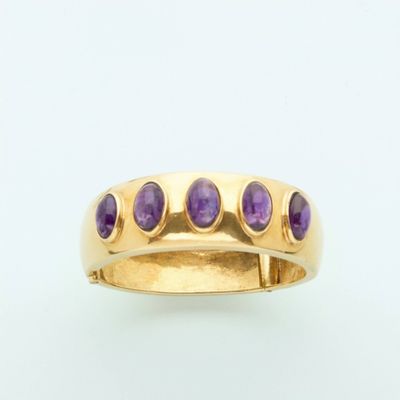 a close up of a gold ring with purple stones on it