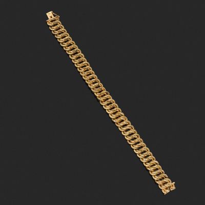un bracelet à chaîne en or avec un fermoir sur fond noir