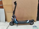 a scooter sitting on the sidewalk next to a cardboard box