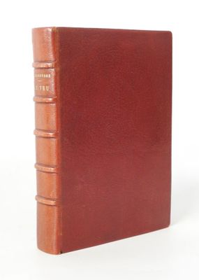 an old book with a brown cover sitting on top of a white surface