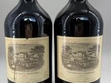 two bottles of red wine sitting next to each other on a table
