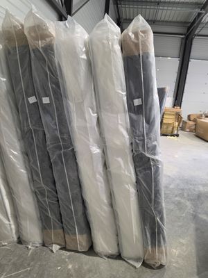 de nombreux rouleaux de tissu posés à même le sol dans un entrepôt