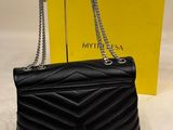 a black bag with a chain hanging from it next to a yellow box
