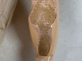 a doll with a broken leg sitting on a chair