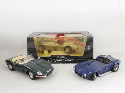 two toy cars are sitting in a box on a white surface