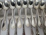 a lot of silver spoons and forks on the table