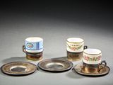 quatre tasses et soucoupes posées sur une table