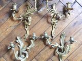 three antique brass wall sconces on a wooden floor
