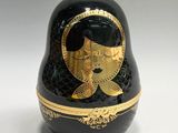 a black and gold matry with a woman ' s face painted on it