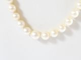 a close up of a pearl necklace on a mannequin mannequin