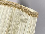 a white lamp with a gold trim and a white shade
