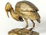 statue of a bird on a rock with a fish in it ' s beak