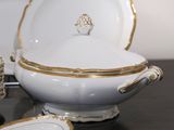 a white bowl with gold trim and a plate on a table
