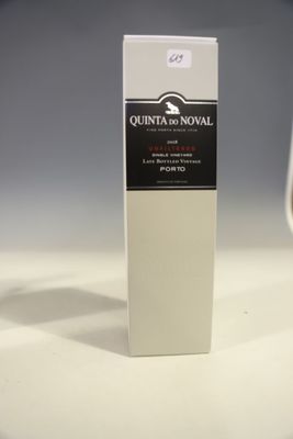 une bouteille de vin posée sur une table à côté d'un verre de vin