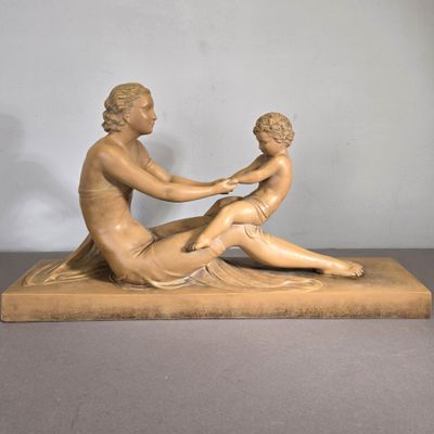 statue représentant une femme et un enfant assis sur un socle en marbre
