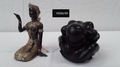une statue représentant une femme assise à côté d'une statue représentant une femme