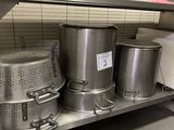 several pots and pans on a metal shelf in a kitchen