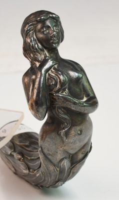 a statue of a woman sitting on top of a boat