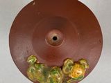 a brown plate with a green and yellow design on it